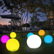 Colorful LED light balls on grass with outdoor setting