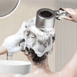 Person using a handheld showerhead with soap suds in a bathroom setting