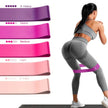 Woman exercising with resistance bands of different weights on a white background