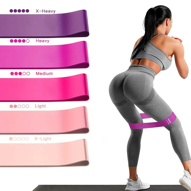 Woman exercising with resistance bands of different weights on a white background