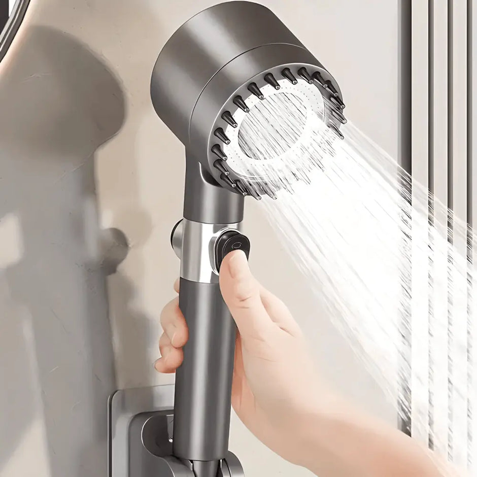 Handheld shower head with water flowing, held by a hand against a neutral background