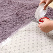 Person cutting clear tape with scissors on a textured surface