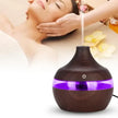 Aromatherapy diffuser with a blurred background of a person receiving a massage.