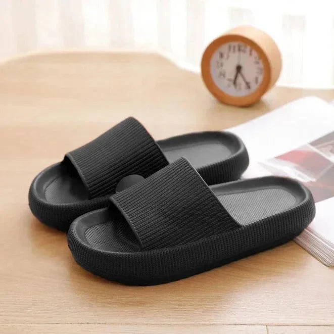 Black slippers on a wooden surface with a clock in the background