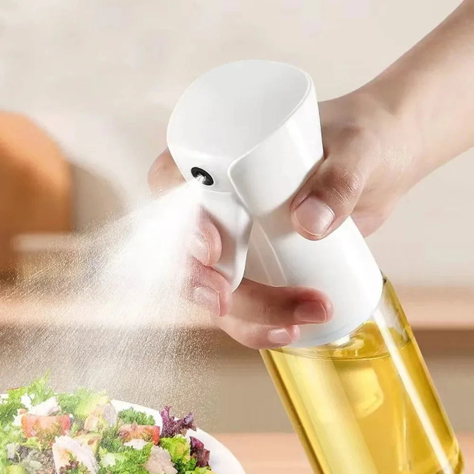 Person using a white oil sprayer over a salad