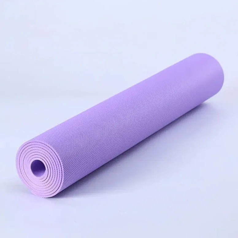 Purple yoga mat rolled up on a light purple background