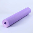 Purple yoga mat rolled up on a light purple background