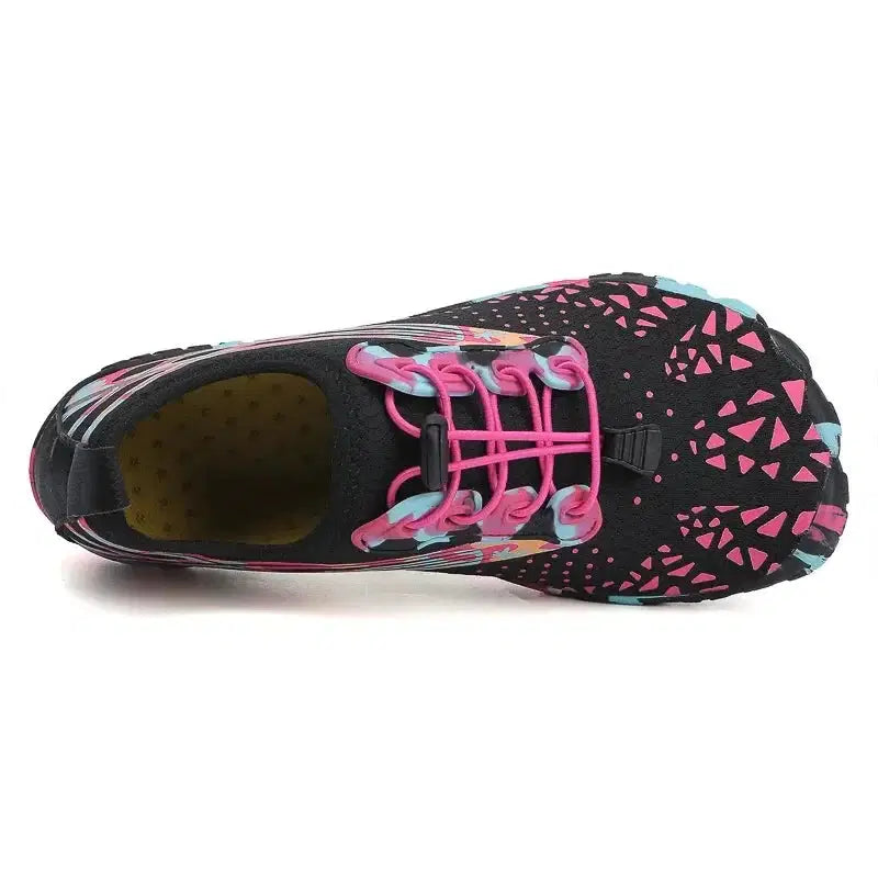 Black athletic shoe with pink laces and colorful pattern on a white background