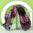 Black and pink patterned shoes on a white surface with a green background