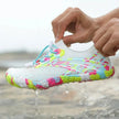 Colorful water shoe with water droplets on a beach background