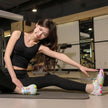 Woman stretching on a mat in a gym setting