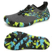 Gray and black athletic shoes with colorful sole design on a white background