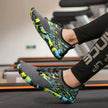 Person wearing gray water shoes with colorful patterns on a treadmill.