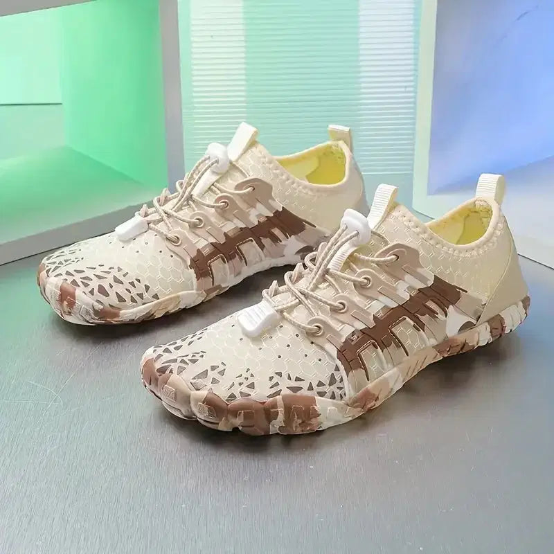 Pair of camouflage-patterned sneakers on a reflective surface with a blurred background