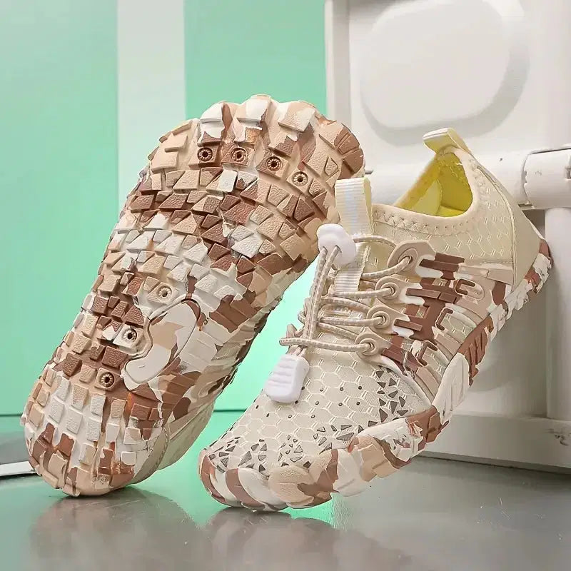 Pair of camouflage-patterned sneakers on a light green background