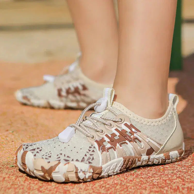 Close-up of beige and brown patterned sneakers on a textured surface