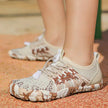 Close-up of beige and brown patterned sneakers on a textured surface