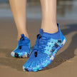 Blue water shoes with a unique design on a sandy surface