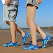 Two people walking on a beach wearing blue shoes with a blurred background