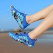 Blue water shoes worn by a person on a beach with clear blue sky.