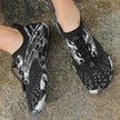 Black and gray athletic shoes on a concrete surface