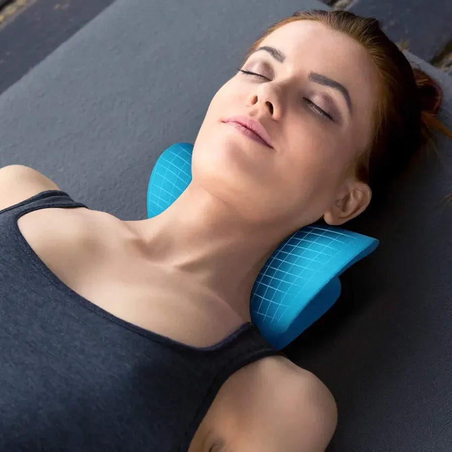 Woman using a blue neck pillow on a dark surface
