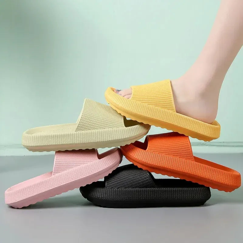 Four colorful slippers stacked on a light green background