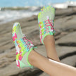 Colorful beach shoes on a person's feet with a blurred beach background