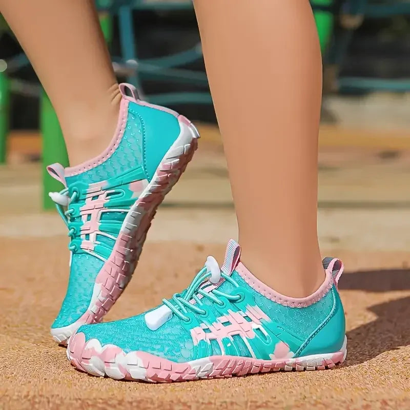 Teal and pink shoes on a sandy surface