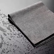 Gray microfiber cloth on a wet surface with water droplets