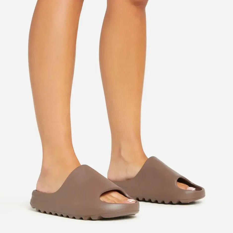Brown sandals worn by a person on a white background