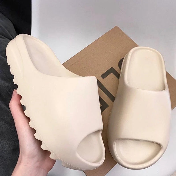Beige slides held by a hand with a box in the background