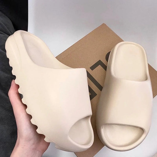 Beige slides held by a hand with a box in the background