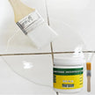 Container of ureththane waterproof coating with a brush on a tiled surface