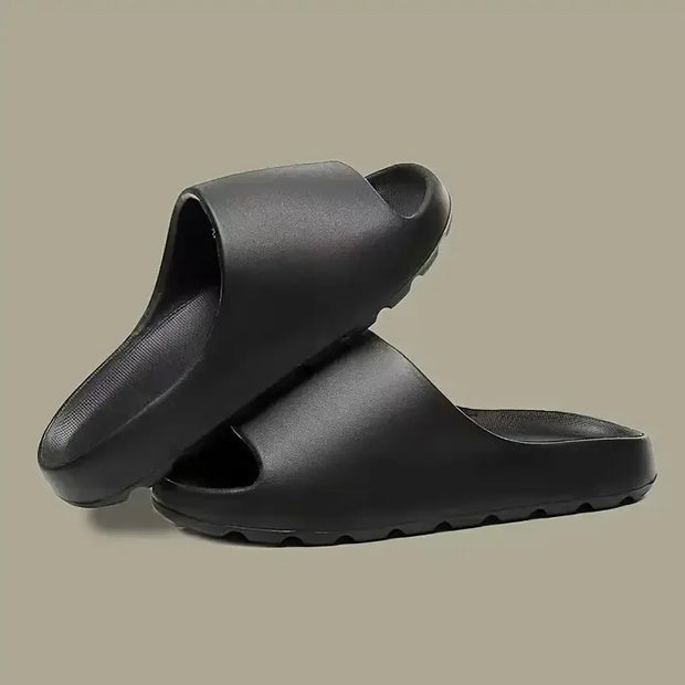 Black rubber slides on a beige background