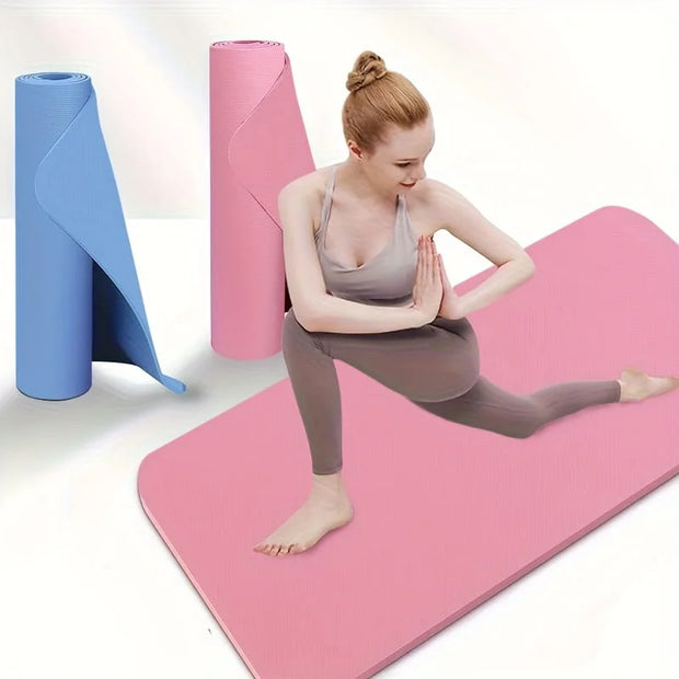Woman practicing yoga on a pink mat with blue and pink yoga mats in the background.
