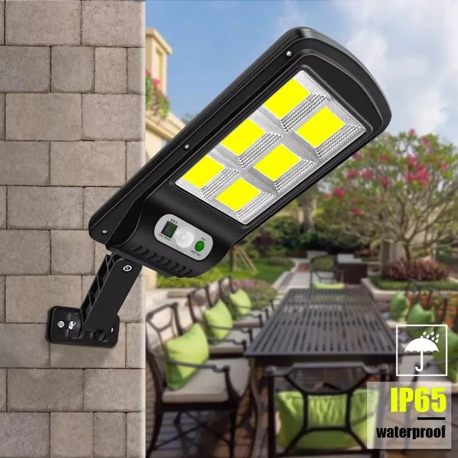 Solar wall light fixture on a stone wall with outdoor furniture in the background