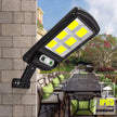 Solar wall light fixture on a stone wall with outdoor furniture in the background
