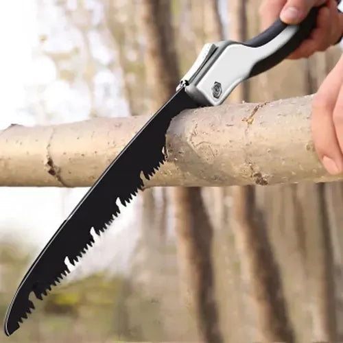Person using a folding saw to cut a branch with a blurred forest background