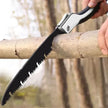 Person using a folding saw to cut a branch with a blurred forest background