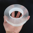 Hand holding a roll of clear adhesive tape against a black background