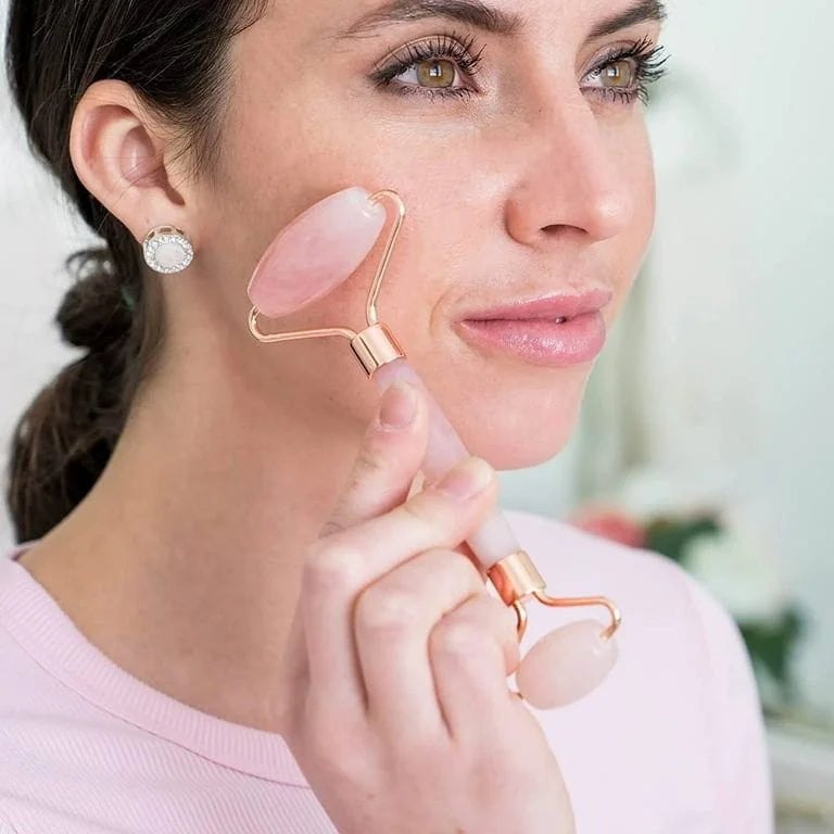 Woman using a rose gold facial roller on her face