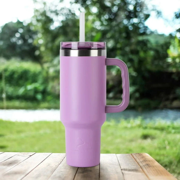 Purple insulated tumbler with a handle on a wooden table outdoors.