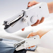 Handheld sewing machine being used on fabric with a plain background