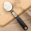 Digital measuring spoon with a wooden background