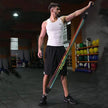 Man exercising with a resistance band in a gym setting