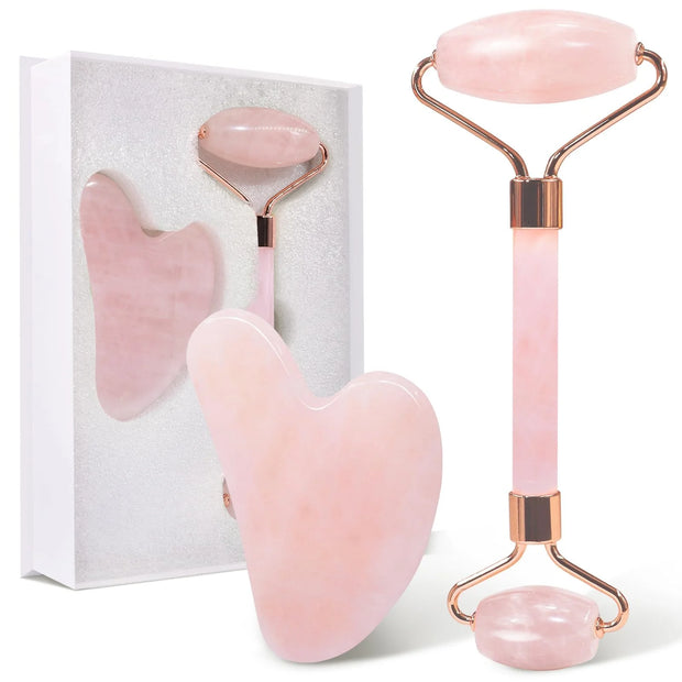 Set of pink facial tools with rose gold accents on a white background