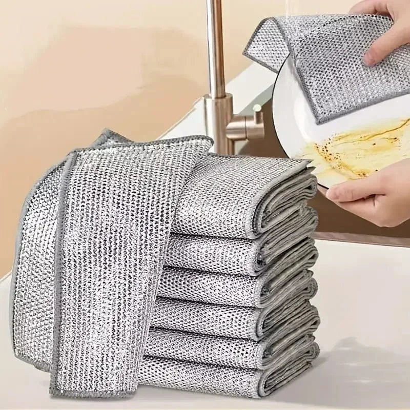 Stack of metallic scrubbing pads with a hand holding one over a sink.