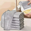 Stack of metallic scrubbing pads with a hand holding one over a sink.