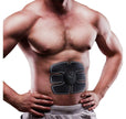 Man wearing an abdominal muscle stimulator device on a white background